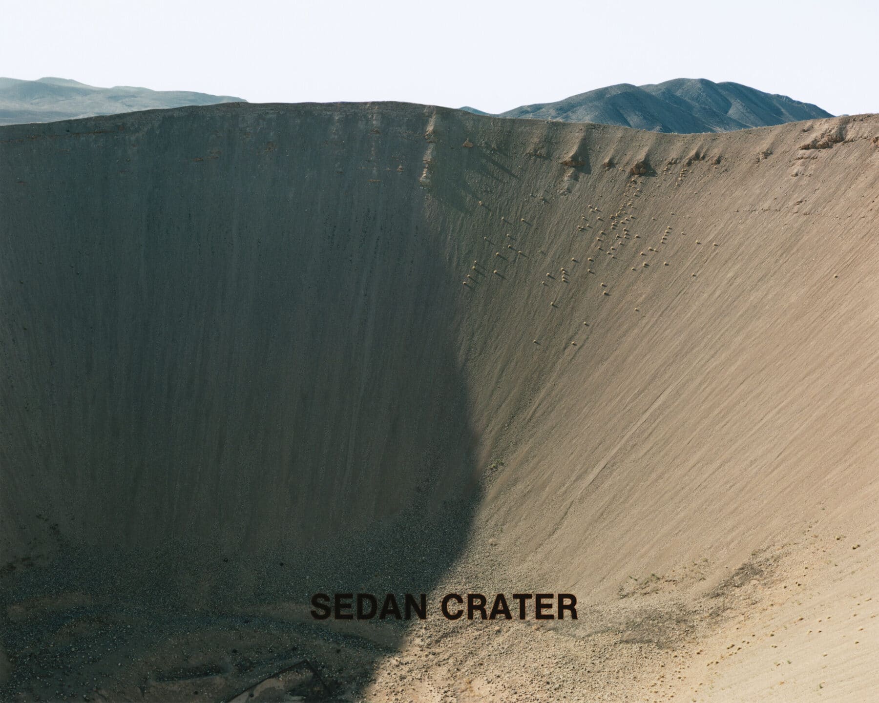 Peter Goin, Sedan Crater, from the book and portfolio Nuclear Landscapes. Original 4 × 5-inch color negative 1987, archival pigment print 2022; scanned, digitized, and printed on Canson Infinity Rag Photographique 310 gsm matte. Courtesy of the artist, © Peter Goin.